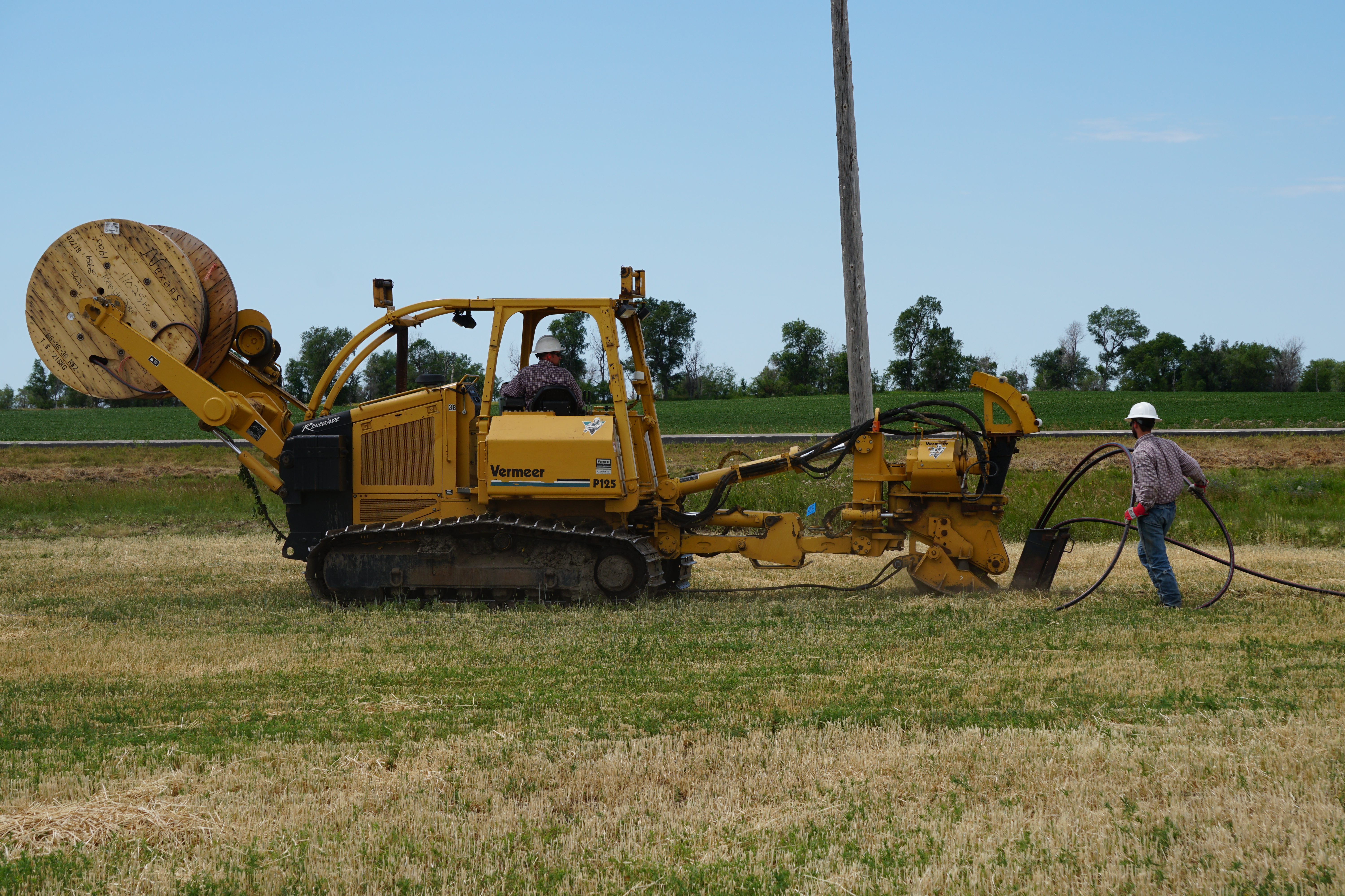 workers operating a trencher